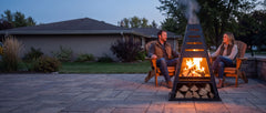 Pyro Tower on a stone patio with a couple beside the fire